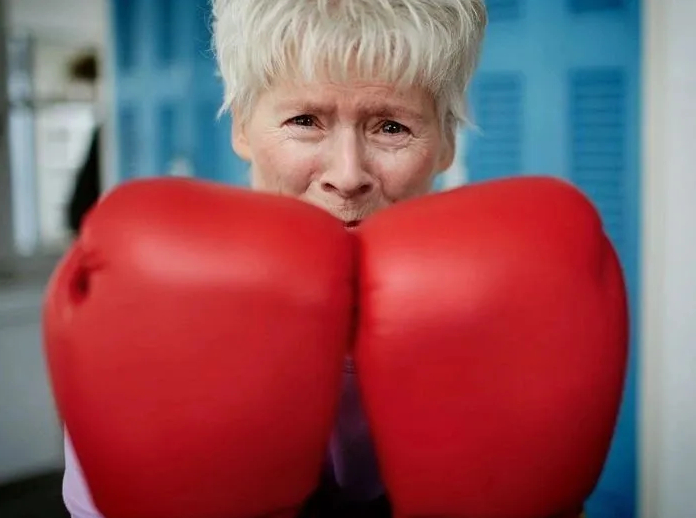 Rock Steady Boxing Santa Monica participant boxing with red gloves